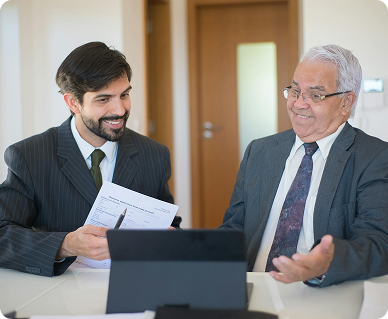 Two businessmen discussing a document at a meeting.